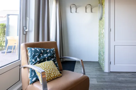 Fauteuil en entree met wandhaken en spiegel Hotel appartement sauna Tjermelan Terschelling